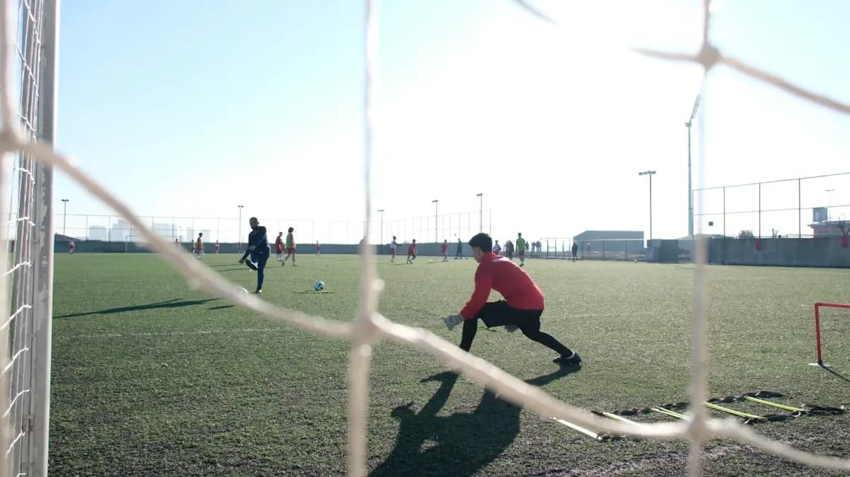 Training von hinter dem Tor gesehen, der Torwart streckt sich nach dem Ball