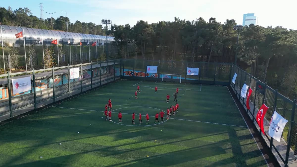 Kapalı sahanın havadan görünümü; oyuncular orta yuvarlakta toplanmış