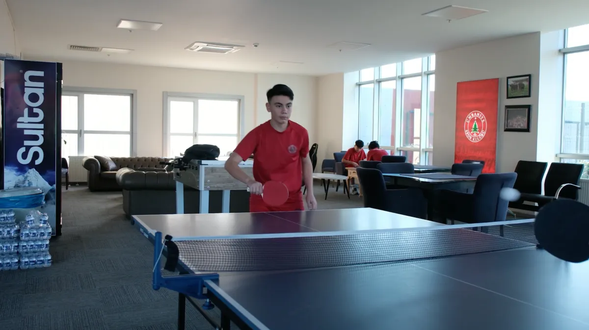 Sosyal alanda masa tenisi oynayan altyapı oyuncusu